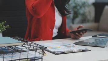 Asian Businesswoman Using laptop computer and working at office with calculator document on desk, doing planning analyzing the financial report, business plan investment, finance analysis concept. video