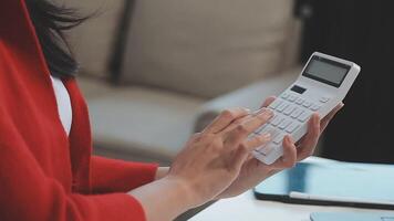 Asian Businesswoman Using laptop computer and working at office with calculator document on desk, doing planning analyzing the financial report, business plan investment, finance analysis concept. video