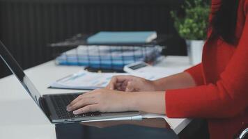 Asian Businesswoman Using laptop computer and working at office with calculator document on desk, doing planning analyzing the financial report, business plan investment, finance analysis concept. video