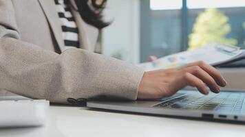 Asian Businesswoman Using laptop computer and working at office with calculator document on desk, doing planning analyzing the financial report, business plan investment, finance analysis concept. video