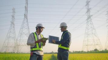 Two men are standing in a field, one of them is talking on a cell phone. The other man is holding a clipboard and looking up at the sky. Scene is serious and focused video