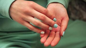 In this , female hands close-up reveal fingers picking up pills from the palm green color of clothes and nails draws attention to hands and the pills, creating a visually appealing composition. video