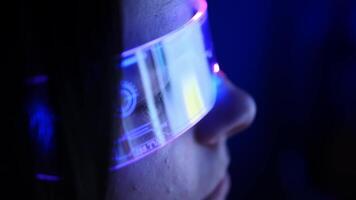 erfarenhet de skärande kant av teknologi som en ung kvinna nedsänker själv i virtuell verklighet, henne virtuell verklighet glasögon Utsmyckad med en fängslande neon glöd, belysande de digital rike video