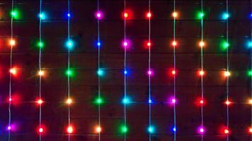Close-up on a full frame colorful lights flashing on a wooden wall. video