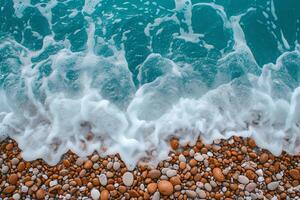 Sea waves crashing brown pebbles. Waves amongst pebbles on beach. Top view of rocks and sea foam. photo