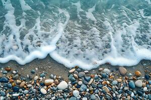 Sea waves crashing. Waves amongst pebbles on beach. Top view of rocks and sea foam. photo