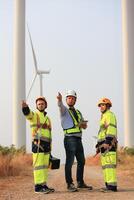 Specialist wind turbine Team of Engineers discussing Green Energy Production in Wind Turbines Farm or Windmills Field. Team of Engineer Energy Planning Activity in Windmills Industrial Area photo