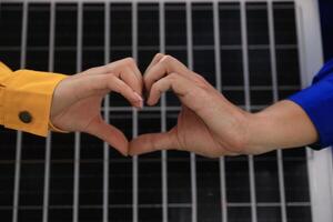 GeneratA couple of engineering workers make heart shapes with solar panel prototypes for renewable energy outdoorsed image photo