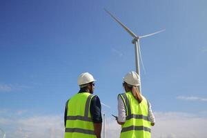 A couple of Electric engineers working together at a wind turbine farm. photo