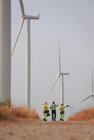 Specialist wind turbine Team of Engineers discussing Green Energy Production in Wind Turbines Farm photo