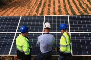 The engineering designer had a discussion with his teamwork at solar panels about the prototype of the solar cell at the field photo