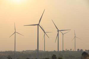 Silhouette Windmill farm generates green energy, a sustainable energy alternative to fossil fuels, fights climate change and global warming with green alternative energy, wind power photo