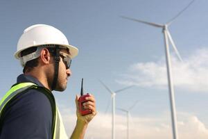 Portrait smart windmill engineer working at wind turbine farm photo