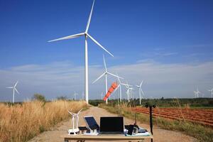 viento turbinas solar célula modelo con viento medición equipo en mesa en frente de enorme viento turbina, viento turbina ingeniero investigación concepto foto