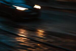 Car lights with highlights on a cobbled road at night photo