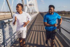 dos afroamericano amigos son trotar en el puente en el ciudad. foto