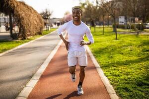 Young african-american man is jogging in the city. photo