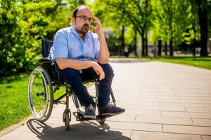Portrait of man in wheelchair. He is worried and thoughtful. photo