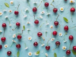 Fresh cherries and daisies covered in water drops and pattern on a pastel blue background. Summertime colorful flat lay photo