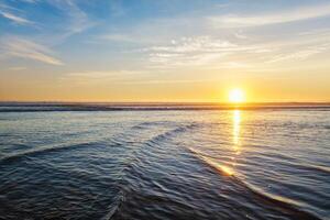 Atlantic ocean sunset with surging waves at Fonte da Telha beach, Portugal photo