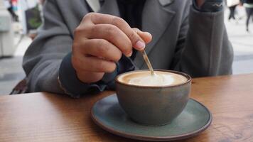 mão de pessoa mexendo café com colher. video