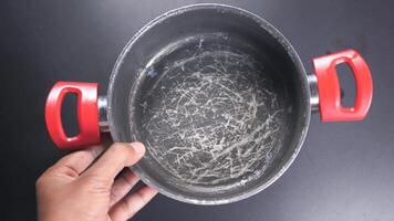 Hand holding scratched frying pan. video