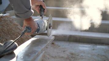 une homme est en utilisant une broyeur à Couper une pièce de béton video