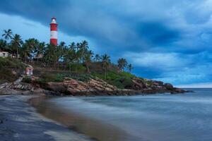 reunión tormenta en playa y faro en puesta de sol. kerala, India foto