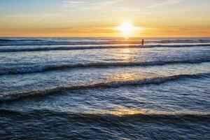 Atlantic ocean sunset with surging waves at Fonte da Telha beach, Portugal photo