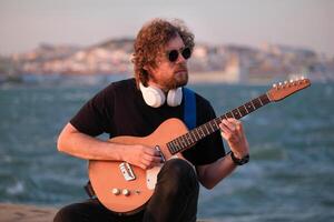 Street musician playing electric guitar in the street photo