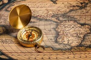 Old vintage golden compass on ancient map photo