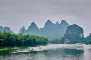 Tourist boats on Li river with carst mountains in the background photo