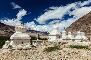 Whitewashed chortens Tibetan Buddhist stupas . Nubra valley, Ladakh, India photo