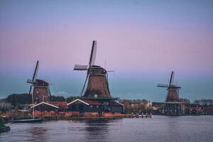 molinos de viento a zaanse schans en Holanda en crepúsculo después puesta de sol. foto