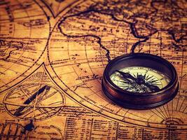 Old vintage compass on ancient map photo