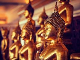 Golden Buddha statues in buddhist temple photo