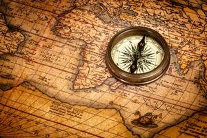 Old vintage compass on ancient map photo