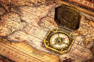 Vintage pirate compass on ancient map photo
