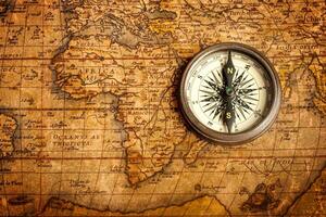 Old vintage compass on ancient map photo