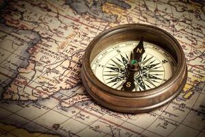 Old vintage compass on ancient map photo