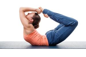 Sporty fit woman practices yoga asana Dhanurasana photo