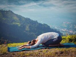 Sporty fit woman practices yoga asana Balasana photo