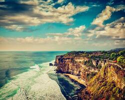 Cliff in ocean on sunset photo