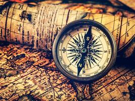 Old vintage compass on ancient map photo