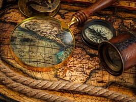 Old vintage compass and navigation instruments on ancient map photo