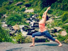 Woman doing Ashtanga Vinyasa Yoga asana Virabhadrasana 1 Warrior photo