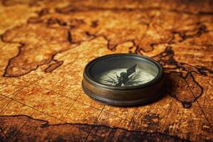 Old vintage compass on ancient map photo