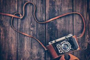 Old retro vintage camera on grunge wooden background photo