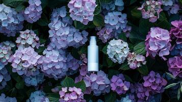 A cream bottle on a flower bed full of darker and light purple flowers. photo