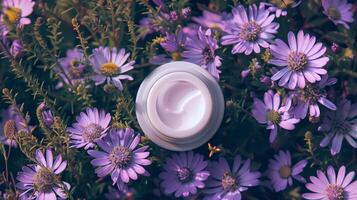A cream bottle on a flower bed full of darker and light purple flowers. photo